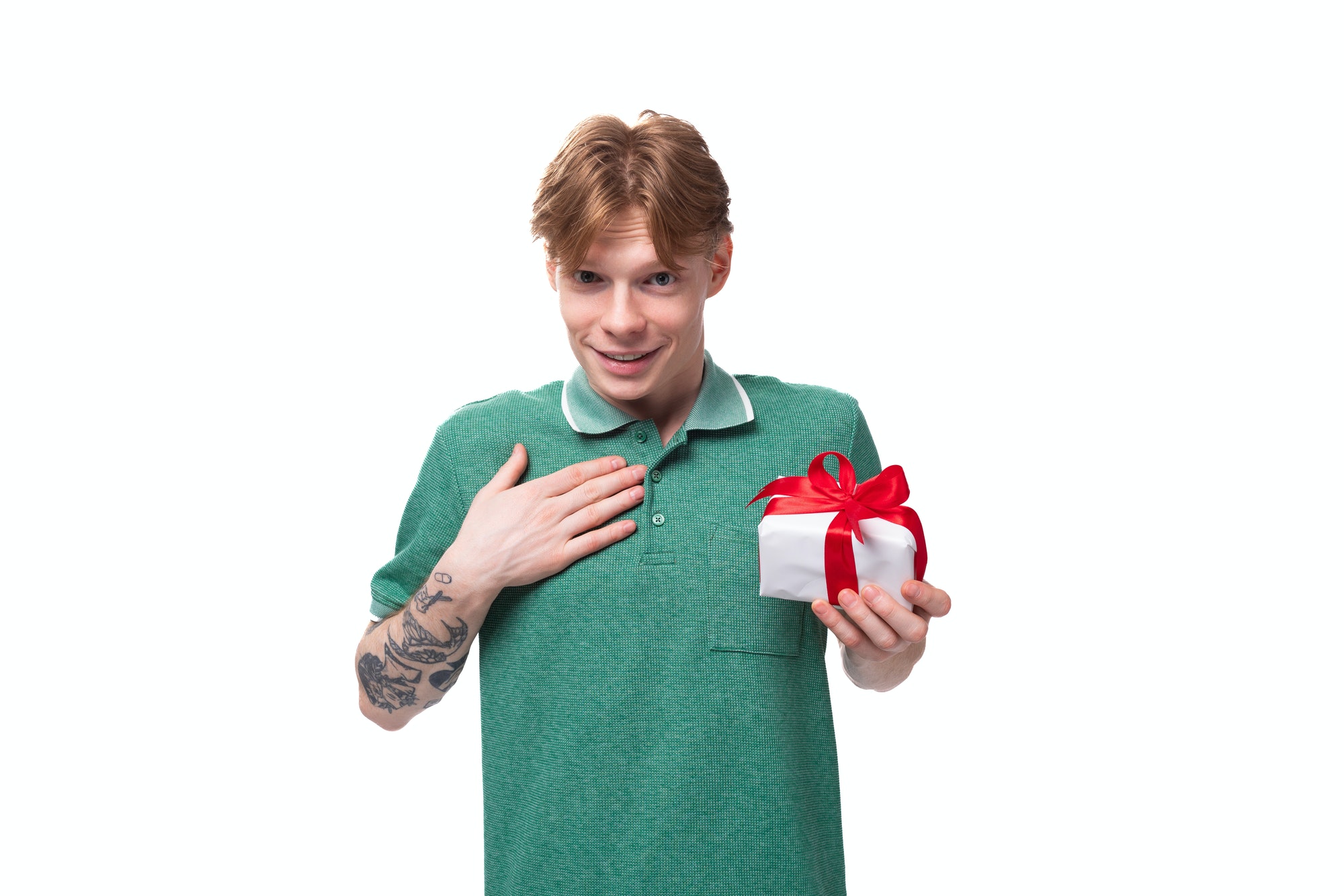 a young man with red hair dressed in a green t-shirt is dreaming about a gift holding a box