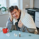 True to Life Image Stressed Man Battles Flu, Headache on Kitchen Chair